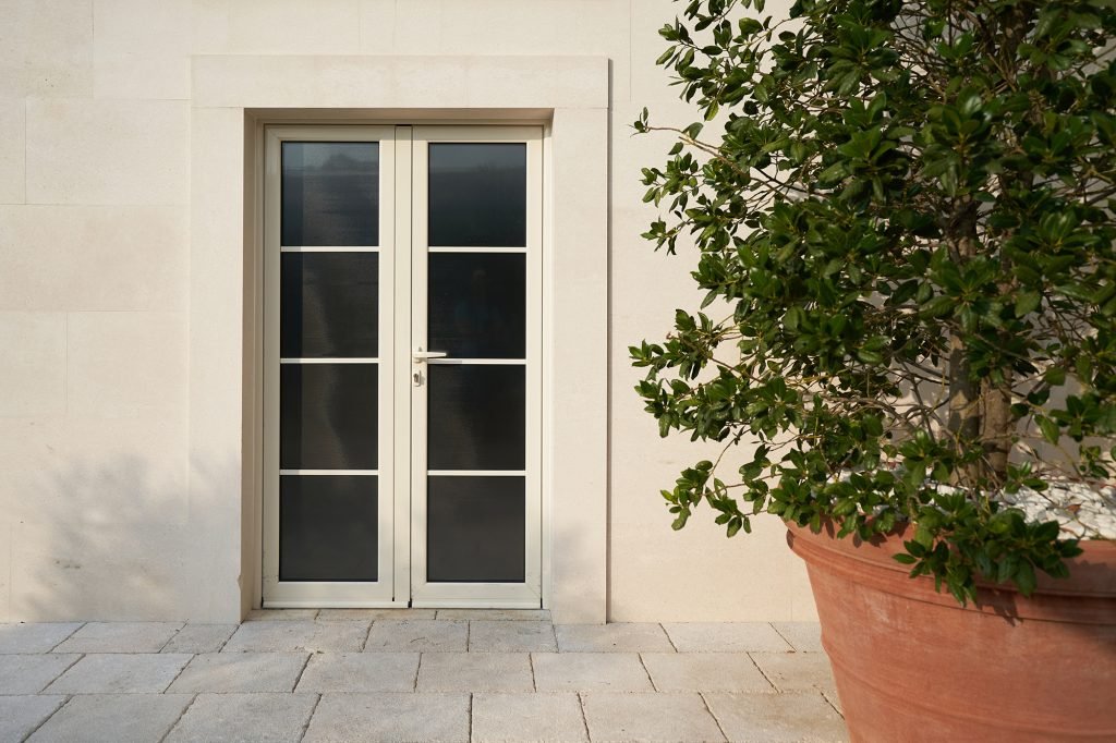 Beige pvc door with glass at the facade of a modern building.